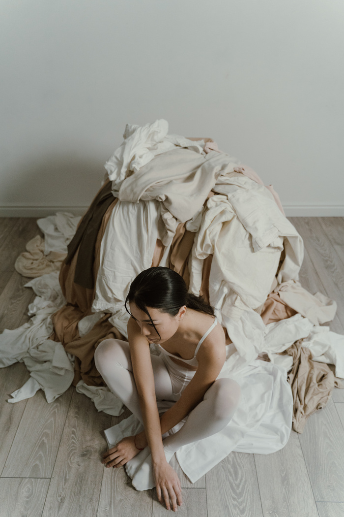 Woman Sitting Near Pile Clothes